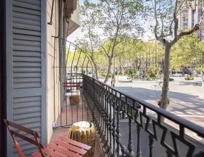 a balcony with two red chairs and a fence at Hotel Casa Trafalgar Barcelona in Barcelona