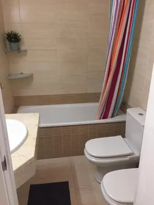 a bathroom with a toilet and a tub and a sink at Luxury Apartment Accommodation, next to beach & train station Calella in Calella