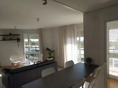 a living room with a dining room table and chairs at Luxury Apartment Accommodation, next to beach & train station Calella in Calella