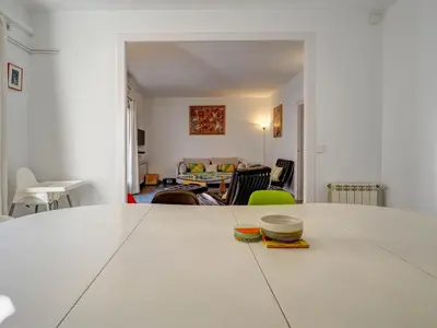 a large white table in a room with a living room at The Lilium Apartment by Hello Homes Sitges in Sitges