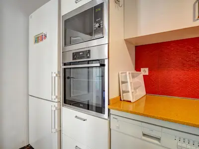 a kitchen with a stove and a microwave at The Lilium Apartment by Hello Homes Sitges in Sitges