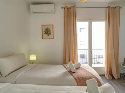a bedroom with a bed and a large window at The Lilium Apartment by Hello Homes Sitges in Sitges