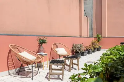 two chairs and a table on a patio with plants at Enjoy Apartments Maria in Barcelona