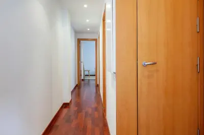 a hallway with a wooden door and a wooden floor at Enjoy Apartments Maria in Barcelona