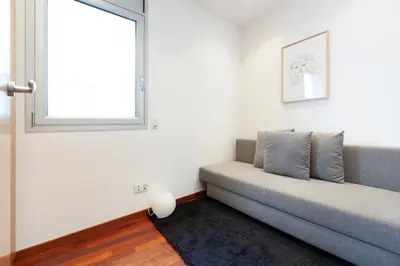 a living room with a couch and a window at Enjoy Apartments Maria in Barcelona