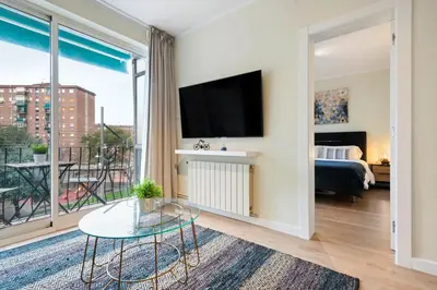 a living room with a bed and a large window at Tendency Apartments Forum 4 in Sant Adria de Besos