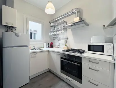 a white kitchen with a stove and a microwave at Stay U-nique Apartments Legalitat in Barcelona