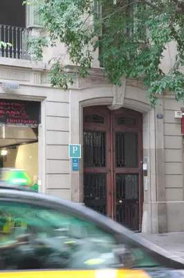 a car in front of a building with two doors at Pensió Cerdanya in Barcelona