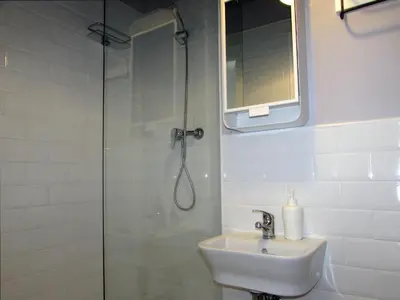 a bathroom with a shower and a sink and a mirror at Pensió Cerdanya in Barcelona