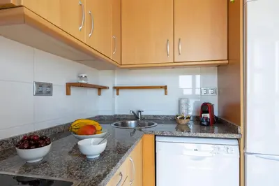 a kitchen with a sink and a bowl of fruit on the counter at matarolux17 in Mataró