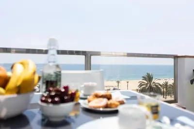 a table with a plate of food and a view of the beach at matarolux17 in Mataró