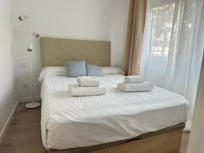 a bedroom with a white bed with towels on it at Beach apartment IV Coeur de Plage in Castelldefels