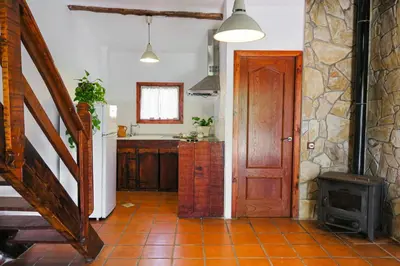 a kitchen with a wooden door and a stove at Masia Pou de la Vinya in Sitges