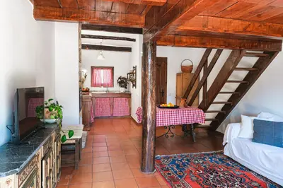 a living room with a table and a kitchen at Masia Pou de la Vinya in Sitges