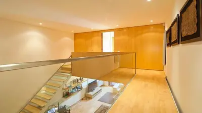 a staircase in a house with a glass railing at Spacious Duplex in Barcelona with outdoor terrace - 180 m² in Barcelona