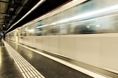 a train is speeding through a subway station at Spacious Duplex in Barcelona with outdoor terrace - 180 m² in Barcelona