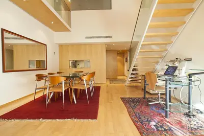 a dining room with a table and chairs and a staircase at Spacious Duplex in Barcelona with outdoor terrace - 180 m² in Barcelona