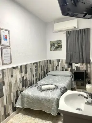 a hospital room with a bed and a sink at Hostal Restaurante Avenida de Madrid in Terrassa
