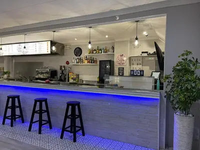 a bar with three bar stools in front at Hostal Restaurante Avenida de Madrid in Terrassa