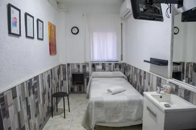 a hospital room with a bed and a sink at Hostal Restaurante Avenida de Madrid in Terrassa