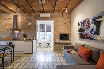 a living room with a couch and a kitchen at Happy People Gaudi Sant Pau Apartments in Barcelona