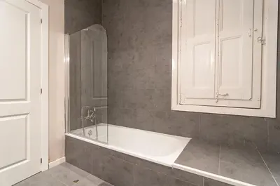 a bathroom with a bath tub and a cabinet at Weflating Ramblas in Barcelona