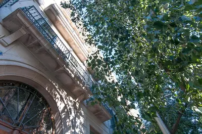 a building with a fence next to a tree at Weflating Ramblas in Barcelona