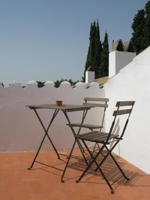 a table and two chairs sitting next to a wall at Casa Le Bouganville in Sant Vicenç de Montalt