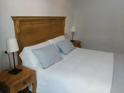 a bedroom with a white bed with two blue pillows at Hostal Portofino in Arenys de Mar