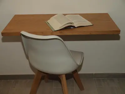a desk with a white chair and an open book at Hostal Portofino in Arenys de Mar