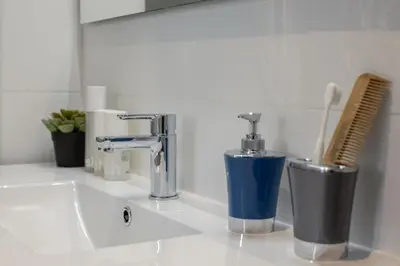 a sink with a faucet and two trash cans at LucasLand Apartments Barcelona in Barcelona