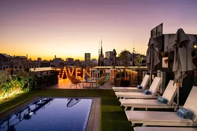 a hotel rooftop with lounge chairs and a pool at Occidental Diagonal 414 in Barcelona