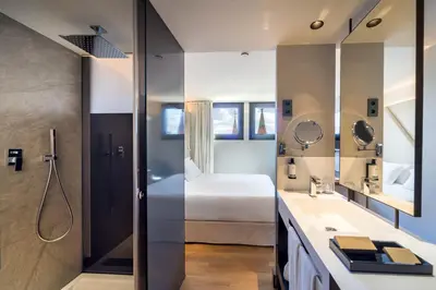 a bathroom with a bedroom with a bed and a sink at Occidental Diagonal 414 in Barcelona