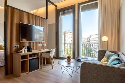 a living room with a couch and a desk with a tv at Occidental Diagonal 414 in Barcelona