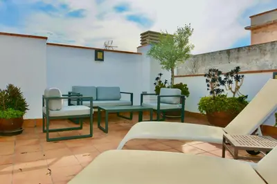 a patio with chairs and tables on a building at Benito Apartment by Hello Homes Sitges in Sitges