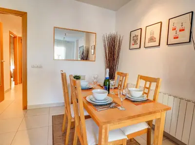 a dining room with a wooden table and chairs at Benito Apartment by Hello Homes Sitges in Sitges