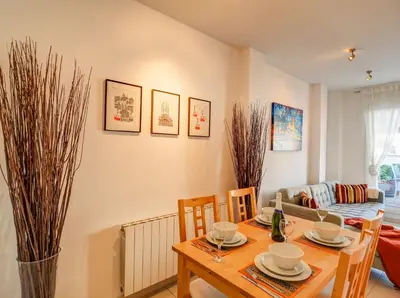 a dining room with a table and a couch at Benito Apartment by Hello Homes Sitges in Sitges