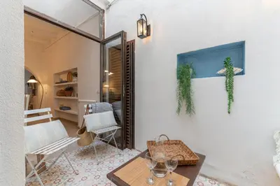 a living room with a table and a chair at Casa Azul by Hello Homes Sitges in Sitges