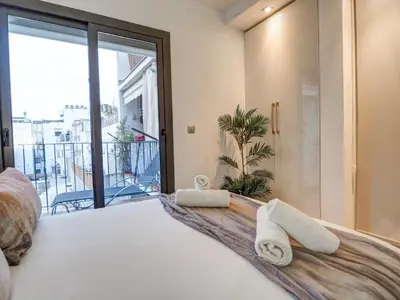 a bedroom with a large bed with towels on it at Chic by Hello Homes Sitges in Sitges