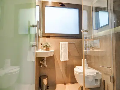 a bathroom with a toilet and a sink and a window at Chic by Hello Homes Sitges in Sitges