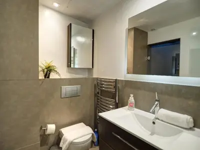 a bathroom with a sink and a toilet and a mirror at Chic by Hello Homes Sitges in Sitges