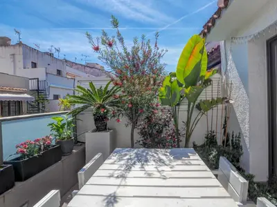 a patio with a table and plants on a balcony at Chic by Hello Homes Sitges in Sitges