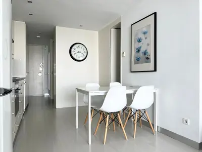 a dining room with a table and white chairs at Vistas Del Mar by Hello Homes Sitges in Sitges