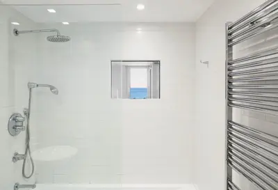 a white bathroom with a shower and a window at Vistas Del Mar by Hello Homes Sitges in Sitges