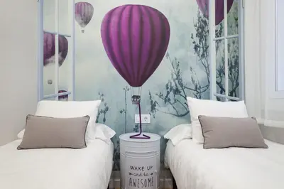 a room with two beds with a balloon on the wall at Art House Paral-lel Sant Antoni in Barcelona