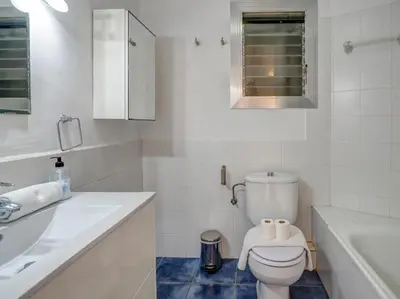 a white bathroom with a toilet and a sink at Soleil by Hello Homes Sitges in Sitges