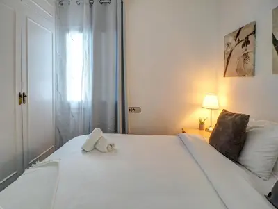 a white bed with a towel on top of it at Soleil by Hello Homes Sitges in Sitges