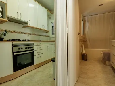 a kitchen with white cabinets and a stove at Diamond by Hello Homes Sitges in Sitges