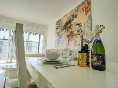 a kitchen with a table with a bottle of wine at Diamond by Hello Homes Sitges in Sitges