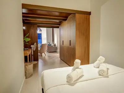 a bedroom with a white bed with towels on it at En Vogue by Hello Homes Sitges in Sitges
